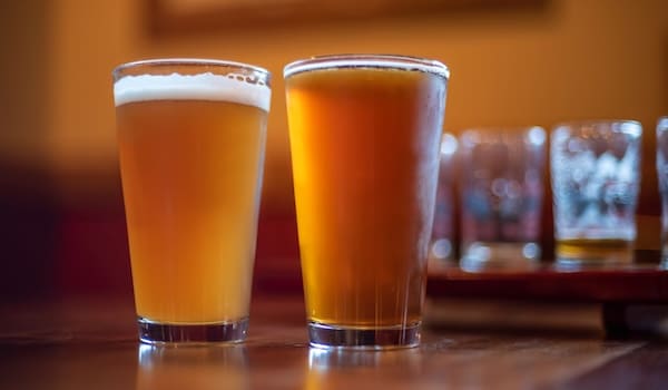 west coast ipa vs neipa - A pint of hazy new england ipa along side a pint of west coast ipa